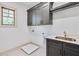 Laundry room features dark cabinets, a stainless steel sink, and a window for natural light at 3927 Enclave Way, Tucker, GA 30084