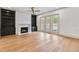 Cozy living room with built-in bookshelves, a fireplace, wood floors, and sliding glass doors to the backyard at 3927 Enclave Way, Tucker, GA 30084