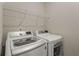 Well-equipped laundry area with a front-load washing machine, dryer, and storage shelf at 4524 Mikajack Se Dr, Smyrna, GA 30080