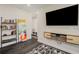 Modern living room with dark floors, wall-mounted TV, bookshelves, and a striking colorful painting at 4524 Mikajack Se Dr, Smyrna, GA 30080