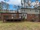 Exterior backyard showing a spacious deck, brick siding, and a well-maintained lawn surrounded by trees at 6390 E Stubbs Rd, Atlanta, GA 30349