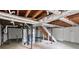 Unfinished basement featuring exposed beams, utilities, and a staircase leading to the upper level at 6390 E Stubbs Rd, Atlanta, GA 30349