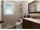 A cozy bathroom featuring a decorative mirror, vanity with sink, toilet and a collection of small decorative wall signs at 2167 Tully Wren Ne, Marietta, GA 30066