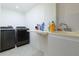 Functional laundry room with washer, dryer, sink, folding shelf, and white walls at 2167 Tully Wren Ne, Marietta, GA 30066