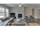 Inviting living room featuring a fireplace, ceiling fan, and comfortable gray sectional sofa at 3410 Summerpoint Xing, Cumming, GA 30028