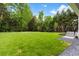 Expansive backyard with lush green lawn, steps to the patio, and manicured landscaping along the tree line at 42 Blackland Nw Rd, Atlanta, GA 30342