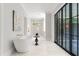 Luxurious bathroom with a freestanding tub, glass doors leading to the outside, and modern fixtures at 42 Blackland Nw Rd, Atlanta, GA 30342