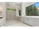 Bright bathroom with a walk-in shower, dual showerheads, and a vanity with marble countertops and elegant fixtures at 42 Blackland Nw Rd, Atlanta, GA 30342