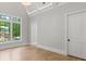 Bedroom with hardwood floors, a large window, white walls, and paneled doors at 42 Blackland Nw Rd, Atlanta, GA 30342