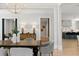 A dining room with a wooden table, upholstered chairs, and chandelier, adjoining a modern kitchen at 42 Blackland Nw Rd, Atlanta, GA 30342