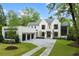 Elegant, all white brick home with black window frames, three-car garage, and professionally landscaped front yard at 42 Blackland Nw Rd, Atlanta, GA 30342