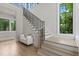 Grand foyer with hardwood floors, staircase, large windows overlooking the lush backyard, and a white cushioned bench at 42 Blackland Nw Rd, Atlanta, GA 30342