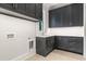 Laundry room boasts ample dark gray cabinets and countertops, with a stainless steel sink and neutral tile floors at 42 Blackland Nw Rd, Atlanta, GA 30342