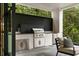 An outdoor kitchen with stainless steel appliances, white brick surround, sink, and stone flooring at 42 Blackland Nw Rd, Atlanta, GA 30342