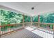 View of the home's covered back porch, with a wood railing, overlooking a wooded area at 6690 Bridge Brook Ovlk, Cumming, GA 30028