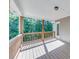 Covered back porch with wood railing, overlooking a wooded area and featuring an exterior door at 6690 Bridge Brook Ovlk, Cumming, GA 30028