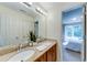 Bright bathroom featuring dual sinks, granite counters, modern fixtures, and a view into the bedroom at 6690 Bridge Brook Ovlk, Cumming, GA 30028