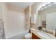 Well-lit bathroom with a shower-over-tub combo, granite countertop, and a modern sink and vanity at 6690 Bridge Brook Ovlk, Cumming, GA 30028