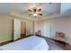 Well-lit bedroom with hardwood floors, seating, and a doorway leading to other areas of the home at 6690 Bridge Brook Ovlk, Cumming, GA 30028