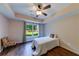 Cozy bedroom with hardwood floors, large windows overlooking the backyard, and a modern ceiling fan at 6690 Bridge Brook Ovlk, Cumming, GA 30028