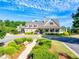 Charming clubhouse with covered porch, surrounded by a well-manicured lawn and lush landscaping, offering a welcoming space at 6690 Bridge Brook Ovlk, Cumming, GA 30028