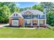 Stunning two-story home featuring a stone and brick facade with a manicured front lawn at 6690 Bridge Brook Ovlk, Cumming, GA 30028