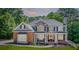 Charming two-story house with a brick facade, a cozy front porch, and mature trees in the background at 6690 Bridge Brook Ovlk, Cumming, GA 30028