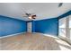 Bright living room featuring hardwood floors, ceiling fan and ample natural light from the large windows at 6690 Bridge Brook Ovlk, Cumming, GA 30028