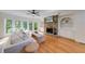 Bright living room featuring hardwood floors, fireplace with stone surround, and built-in shelving at 6690 Bridge Brook Ovlk, Cumming, GA 30028