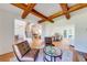 Open concept living room featuring a wood beam ceiling, hardwood floors, and plenty of natural light at 6690 Bridge Brook Ovlk, Cumming, GA 30028