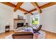 Cozy living room with stone fireplace, wood beam ceiling, and lots of natural light at 6690 Bridge Brook Ovlk, Cumming, GA 30028