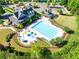 Expansive aerial view of a pristine community pool with splash pad, clubhouse, and surrounding manicured landscaping at 6690 Bridge Brook Ovlk, Cumming, GA 30028