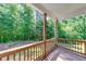 Covered porch showing wood railing and wooded backyard views at 6690 Bridge Brook Ovlk, Cumming, GA 30028