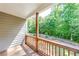 Covered back porch with wood railing and wooded backyard views at 6690 Bridge Brook Ovlk, Cumming, GA 30028