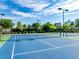 Close-up of a community tennis court showcasing the pristine surface, nets, and lighting fixtures at 6690 Bridge Brook Ovlk, Cumming, GA 30028