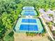 Aerial view of community tennis courts, well-maintained with lush landscaping and lighting for night play at 6690 Bridge Brook Ovlk, Cumming, GA 30028