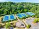 Aerial view of community tennis courts and a playground surrounded by lush trees, offering active recreation at 6690 Bridge Brook Ovlk, Cumming, GA 30028