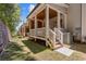 Backyard view showcases a covered porch with wooden steps leading to a grassy area at 224 Trecastle Sq # 22, Canton, GA 30114