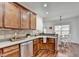 Kitchen area with stainless steel dishwasher, sink and wooden cabinetry with bright view of dining area at 337 Inverness Ave, Mcdonough, GA 30253