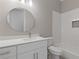 Bright bathroom featuring white cabinets, quartz countertops, and a round mirror at 302 Trecastle Ln # 27, Canton, GA 30114