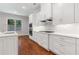 Well-lit kitchen showcasing white cabinets, quartz countertops, and stainless steel appliances at 302 Trecastle Ln # 27, Canton, GA 30114