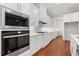 Bright kitchen featuring white cabinets, stainless steel appliances, quartz countertops, and hardwood floors at 302 Trecastle Ln # 27, Canton, GA 30114