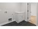 Bright laundry room featuring a white cabinet with a countertop and dark floor tiles at 302 Trecastle Ln # 27, Canton, GA 30114