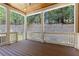 Large screened-in porch with wooden floor, ceiling fan, and view of the backyard wall at 302 Trecastle Ln # 27, Canton, GA 30114