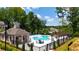 Community pool area featuring a clubhouse, lounge chairs, umbrellas, and lush greenery at 3117 Moor View Rd # 36, Duluth, GA 30096