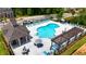 Aerial view of community pool with lounge chairs, umbrellas, and clubhouse at 3117 Moor View Rd # 36, Duluth, GA 30096