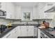 Stylish white kitchen with stainless steel appliances, dark counters, and light backsplash is perfect for cooking and entertaining at 343 8Th Ne St # G2, Atlanta, GA 30309