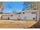 Exterior view of house with patio in backyard and white siding and roof with trees in the background at 6071 Cristie Dr, Ellenwood, GA 30294