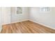 Bedroom featuring light walls, light wood-look flooring, and two windows with blinds at 6071 Cristie Dr, Ellenwood, GA 30294