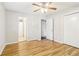 Bedroom with wood floors, ceiling fan, view of hallway and bathroom, and closet at 6071 Cristie Dr, Ellenwood, GA 30294